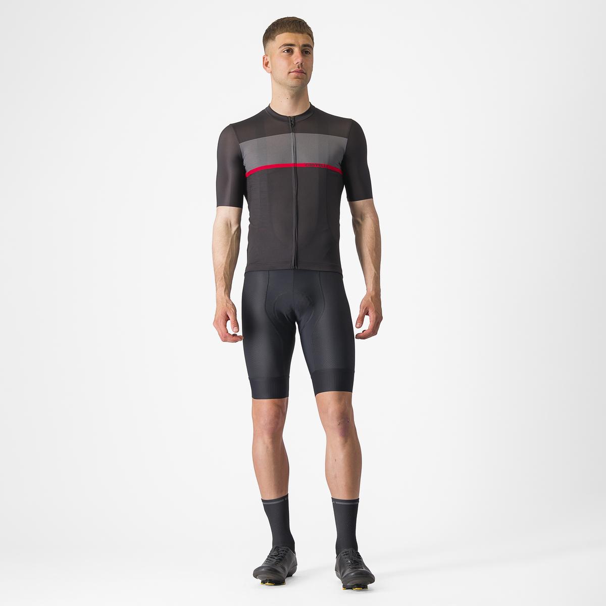 Man wearing a black cycling jersey with a red stripe on a white background
