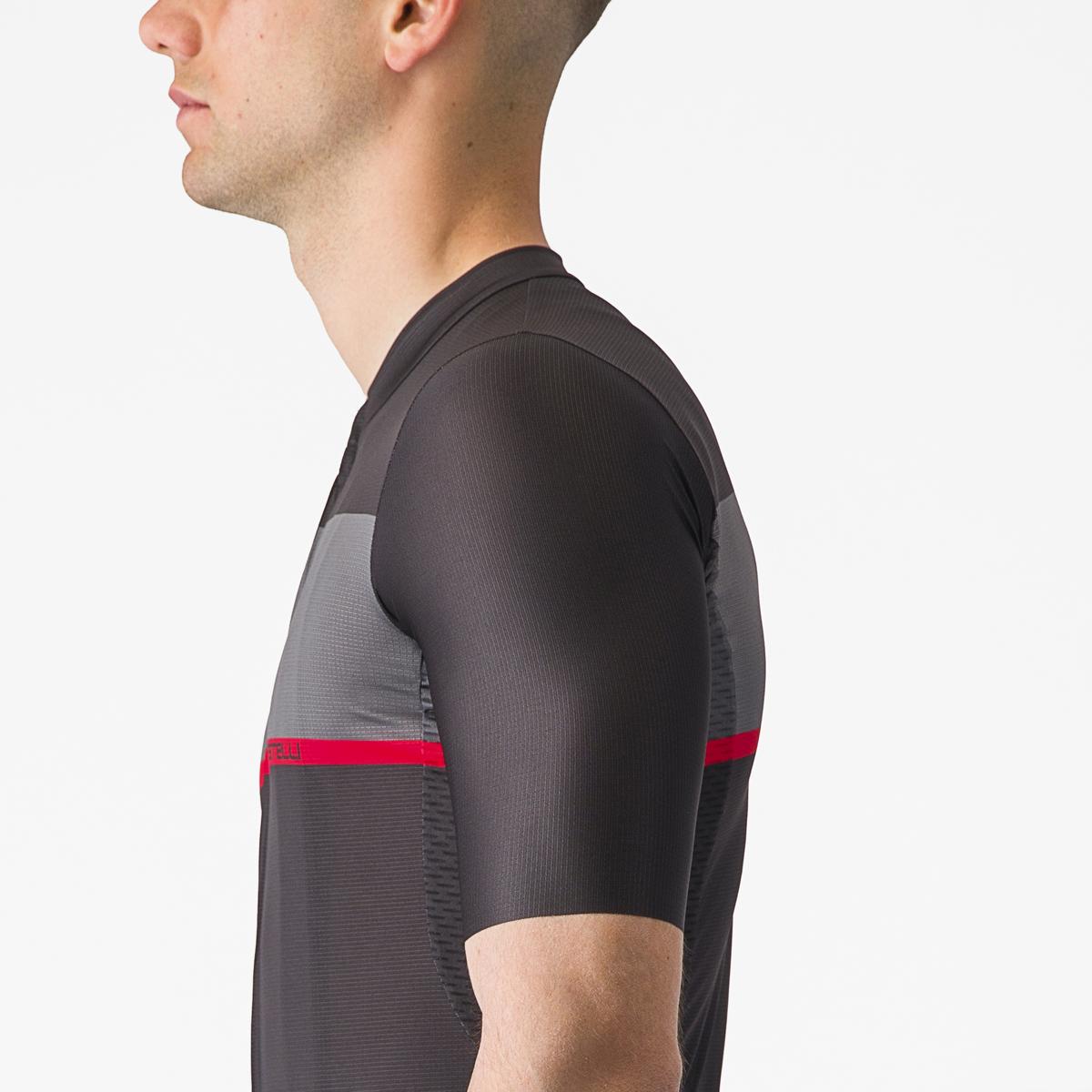 Man wearing a gray cycling jersey with red accents on a white background