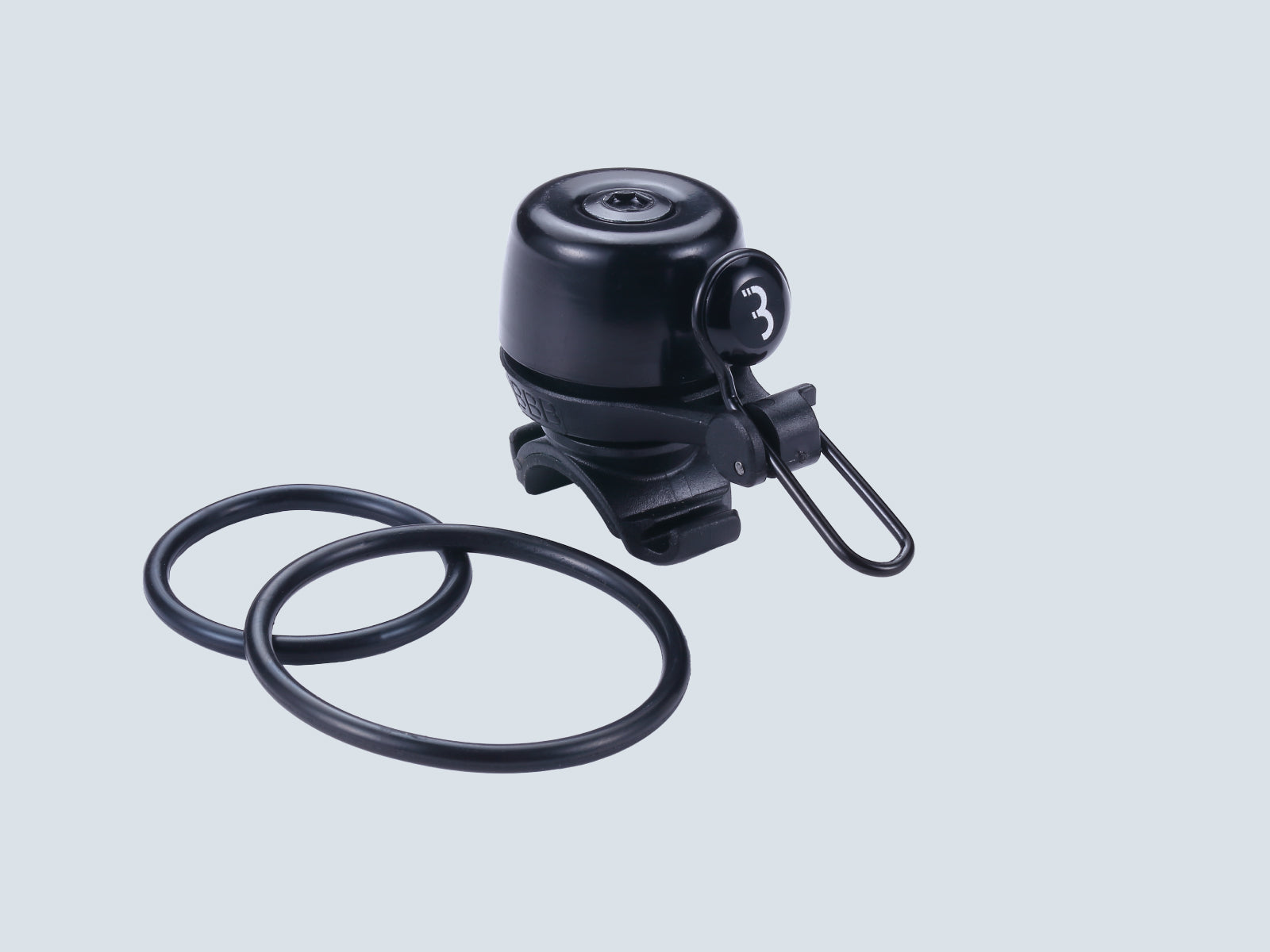 A picture of a bicycle bell with the strap mounts