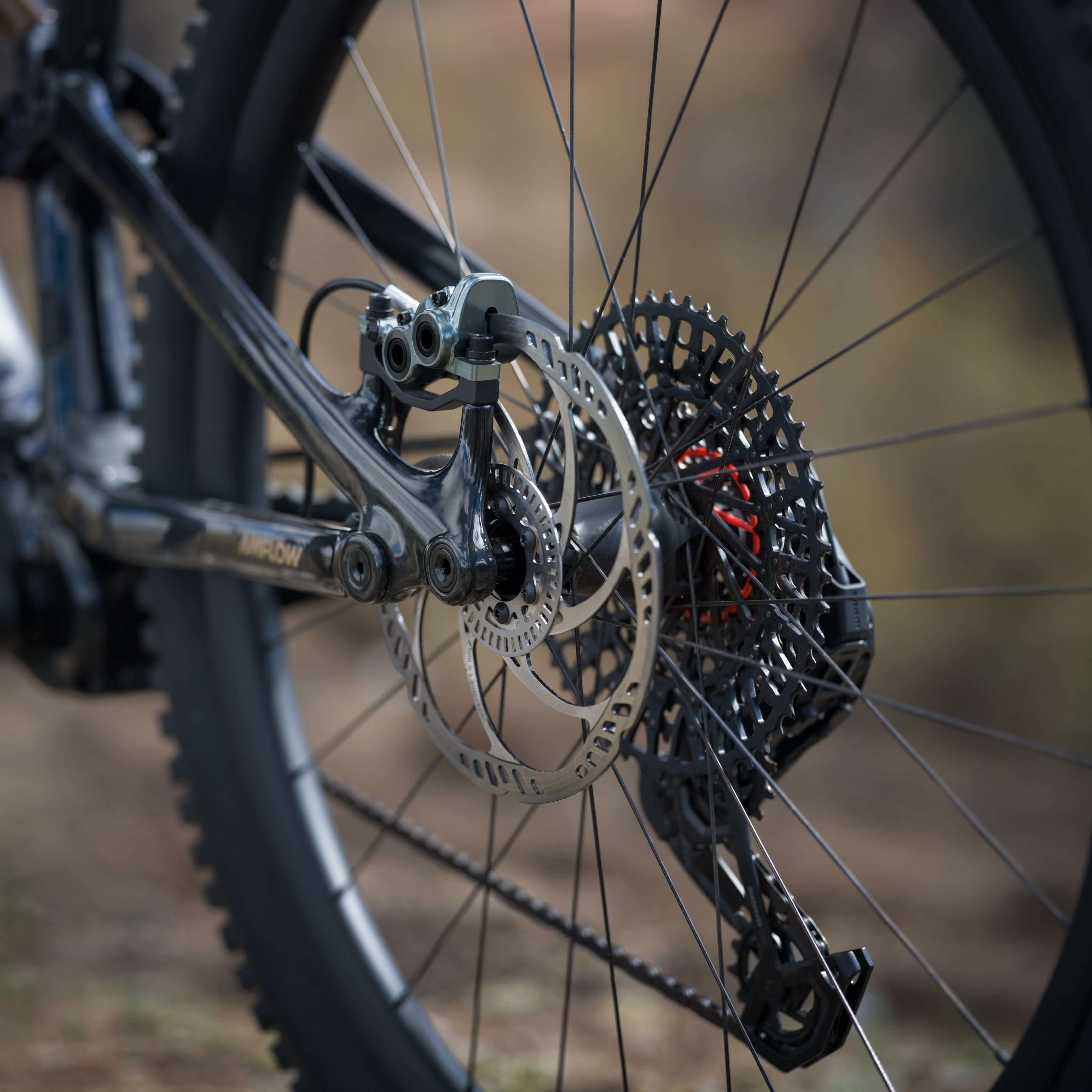 Close-up of a bicycle's gear system with a blurred natural background