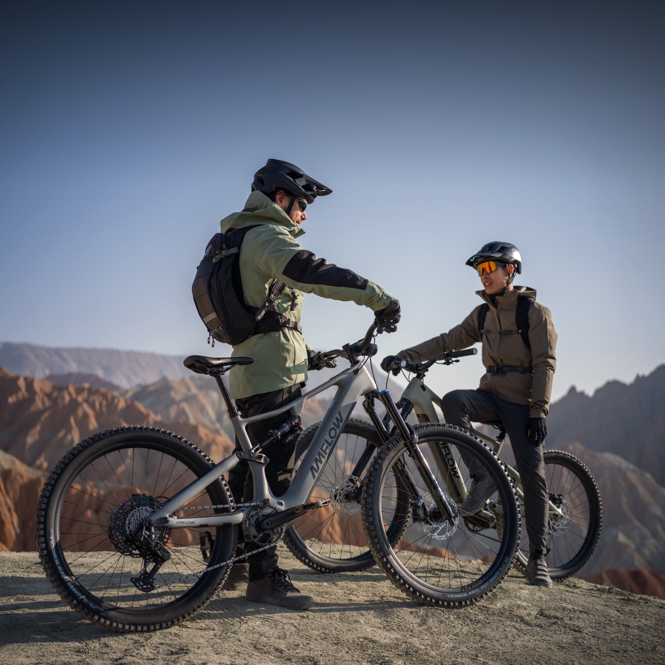 Two mountain bikers standing with their Amflow mountain bikes in a desert landscape