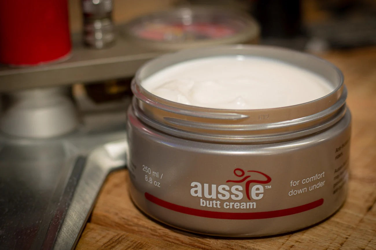Jar of aussie butt cream on a wooden surface with blurred background