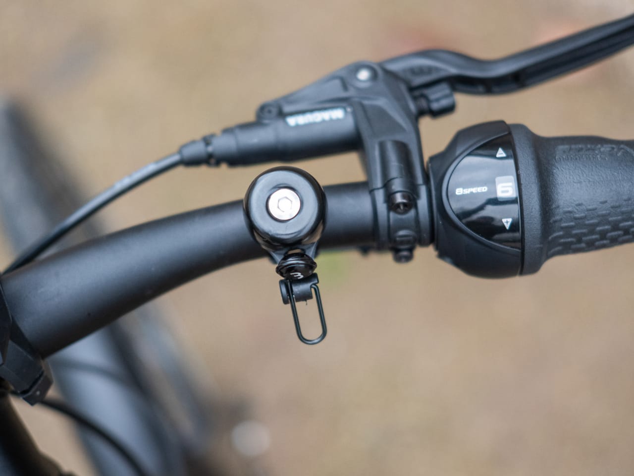 A picture of a bicycle bell on a handlebar