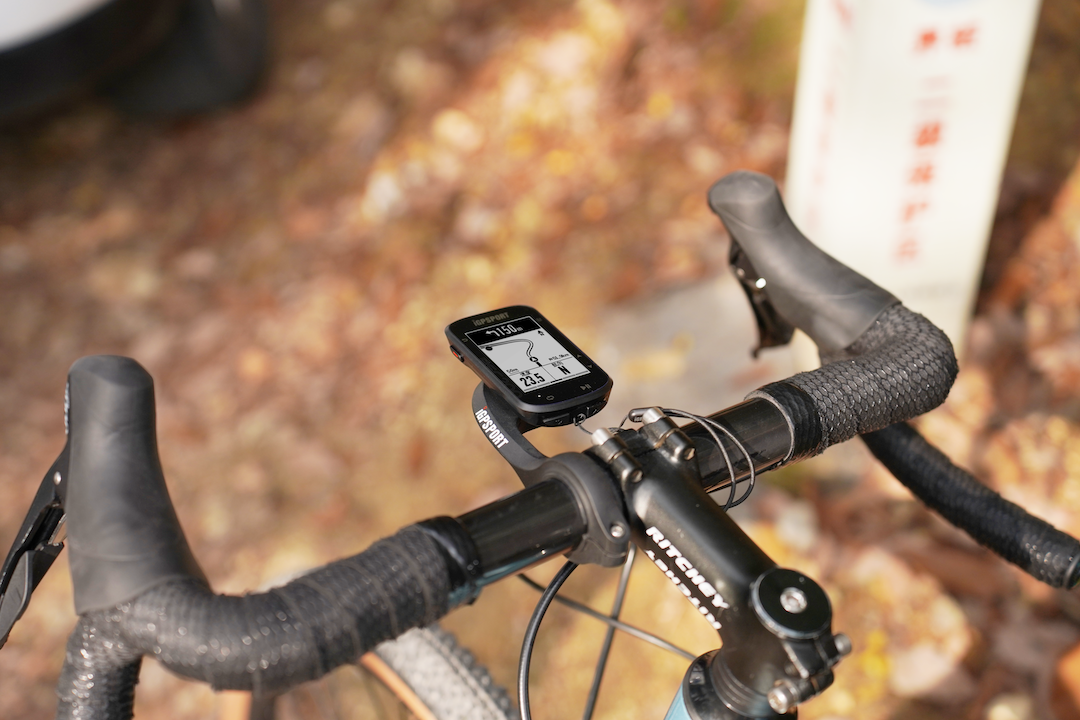 A picture of a cycling computer attached to the handlebars of a road bike