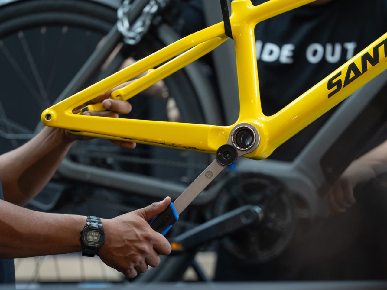 Yellow bicycle frame being worked on by a person.
