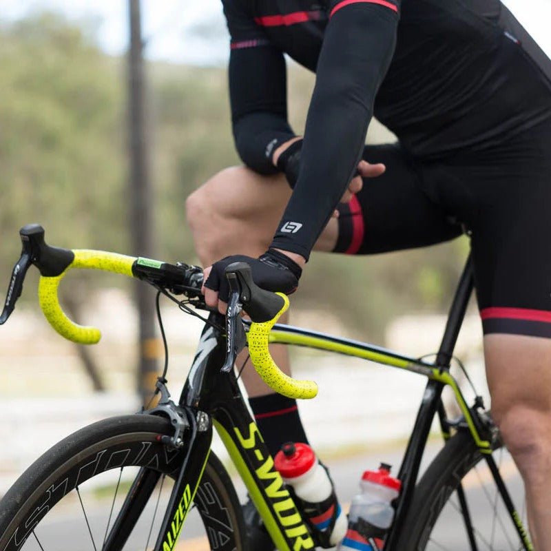 Cyclist on a road bike wearing Bellwether Arm Warmers with a blurred background