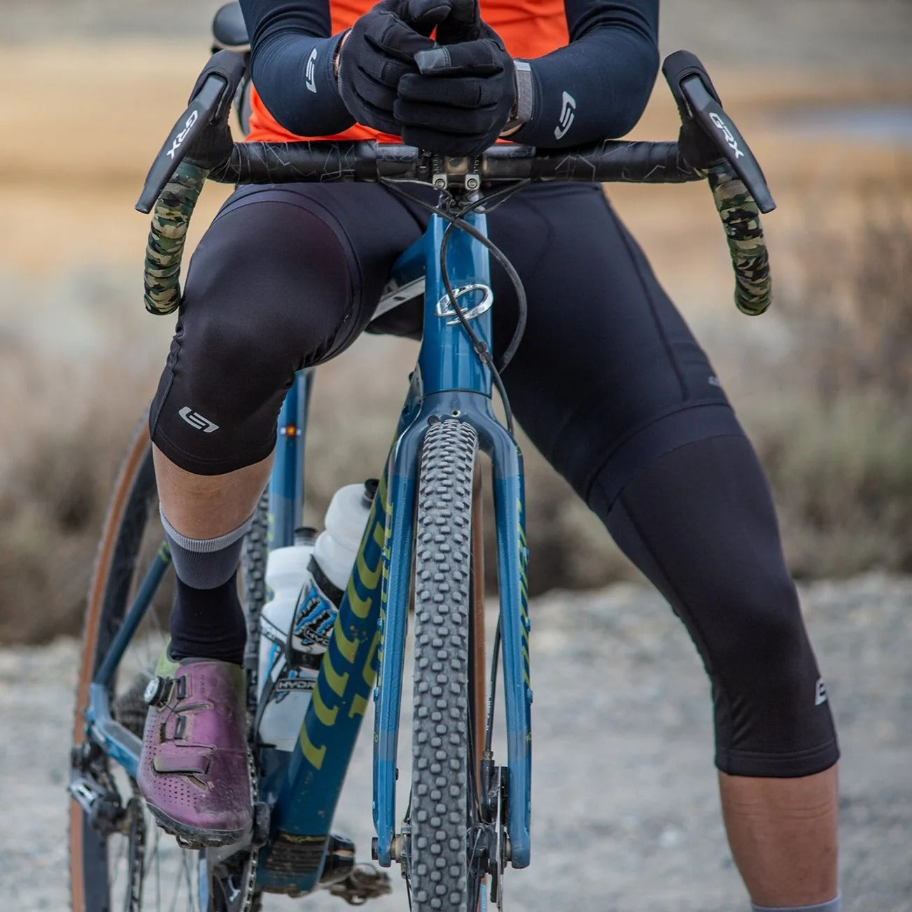 Person on a bicycle wearing cycling gear with a blurred natural background