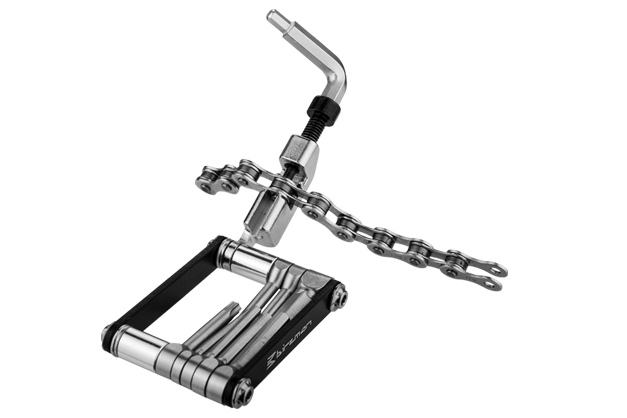 Silver bicycle multi tool with a chain in the chainbreaker tool on a white background