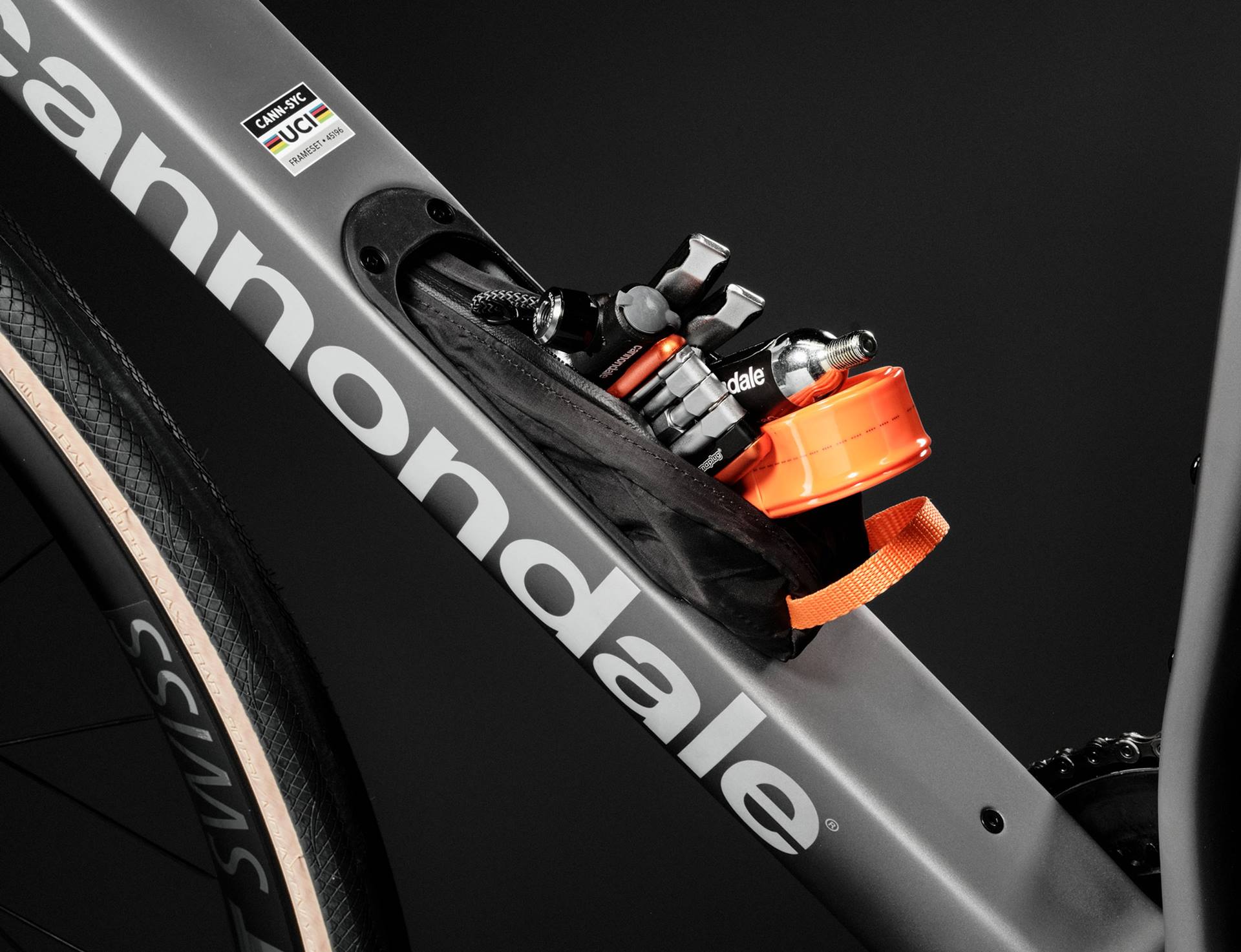 A close up picture of the storage compartment on the frame a Cannondale road bike with tools poking out