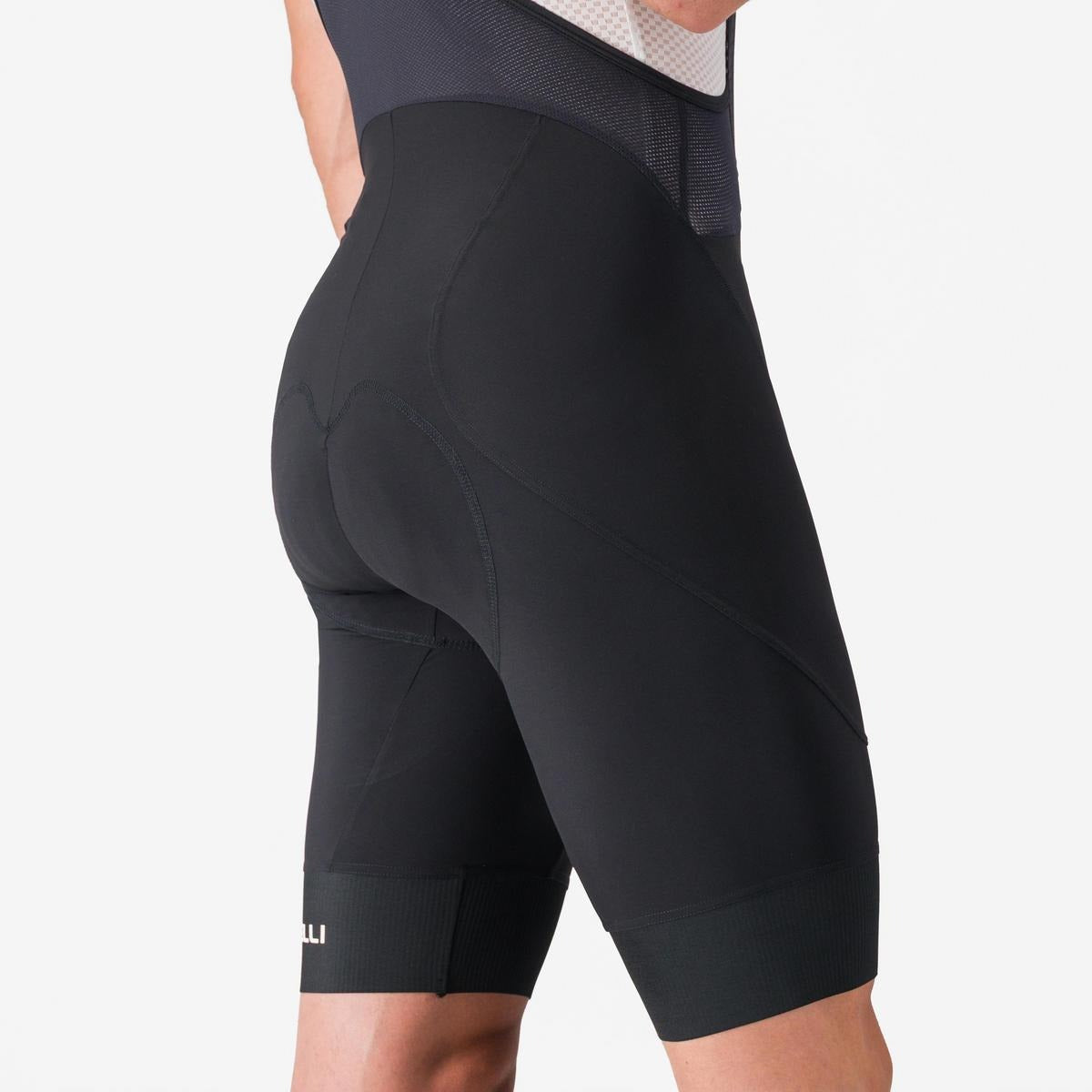 A rear view of someone wearing black cycling big shorts on a light grey background