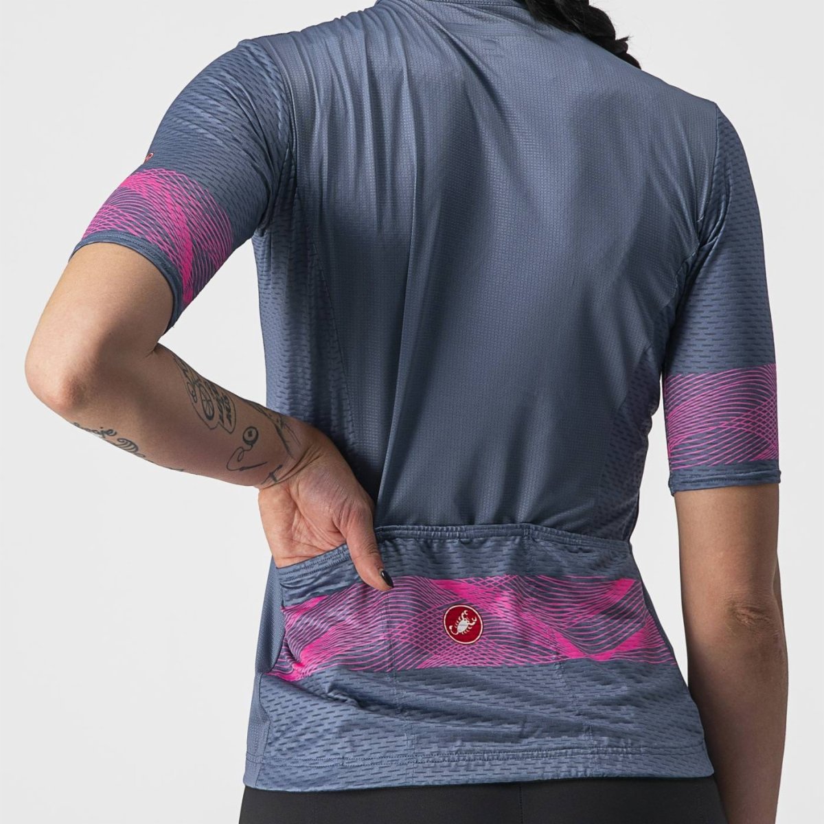 A women showing the back pocket of the Castelli Fenice Road Cycling Jersey