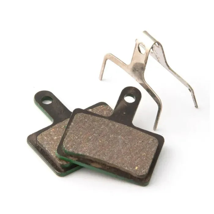 Two disc brake pads with a metal clip on a white background