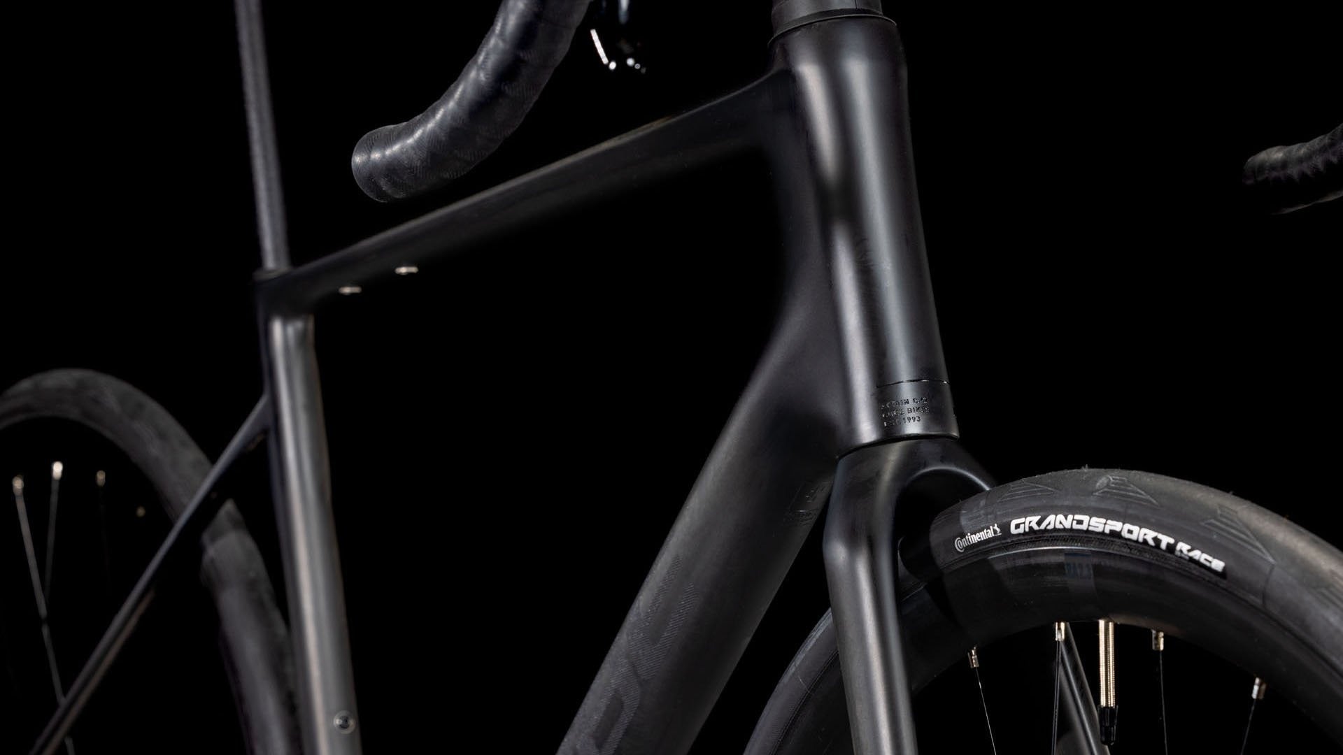 Close-up of a bicycle frame with 'Grande Sport' branding on a black background