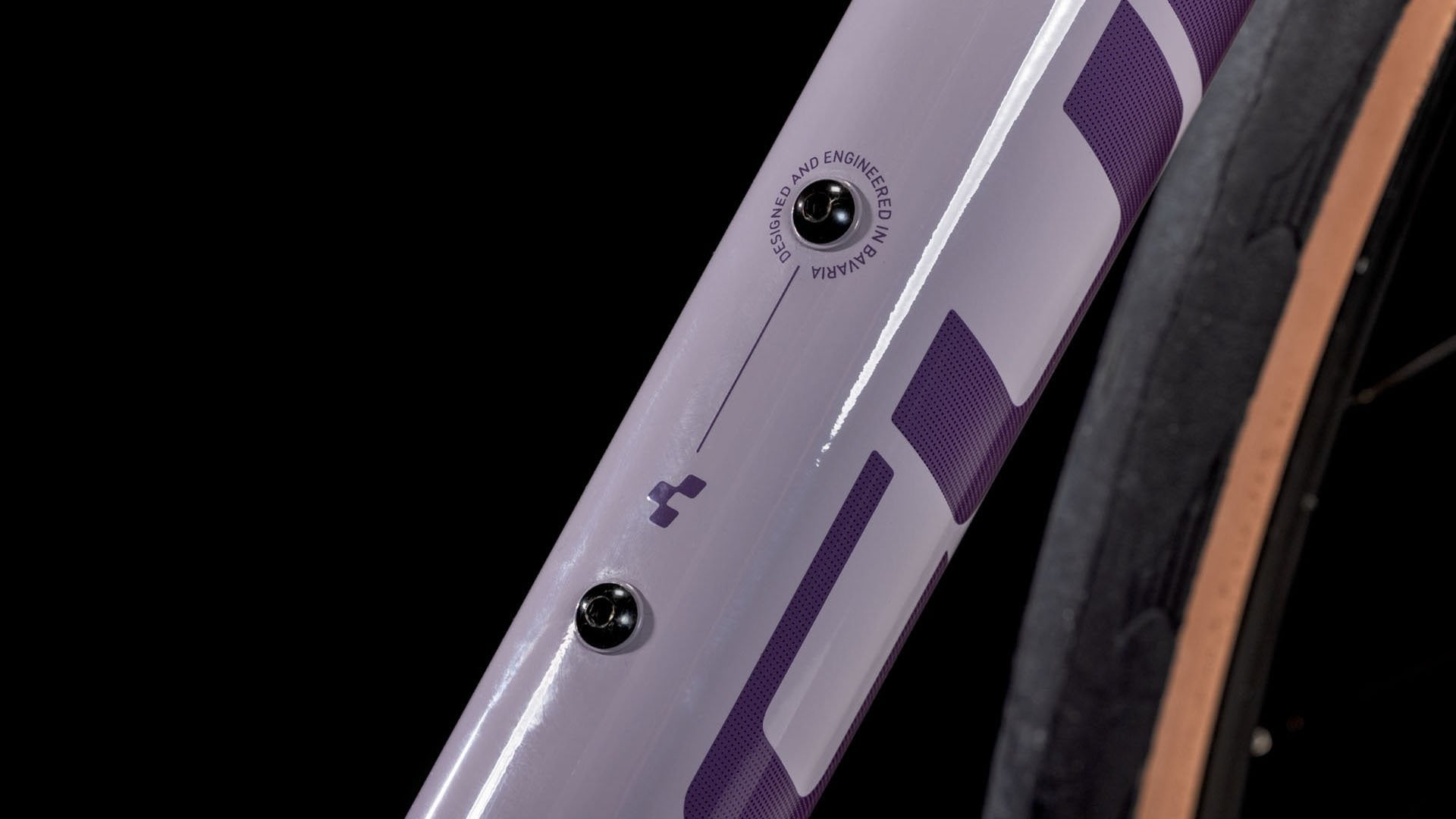 Close-up of a bicycle frame with purple and gray design on a black background