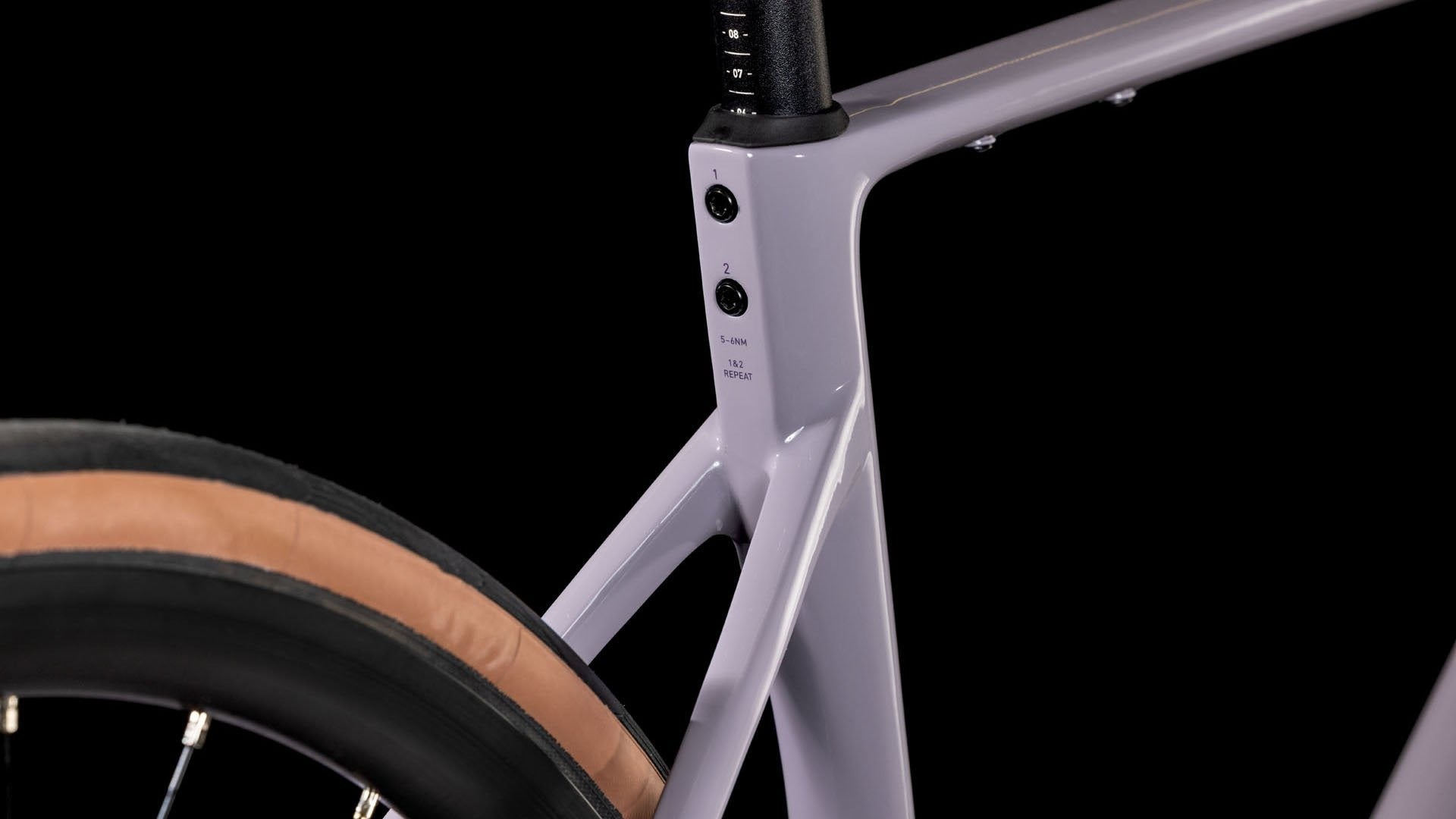 Close-up of a light purple bicycle frame with a black background