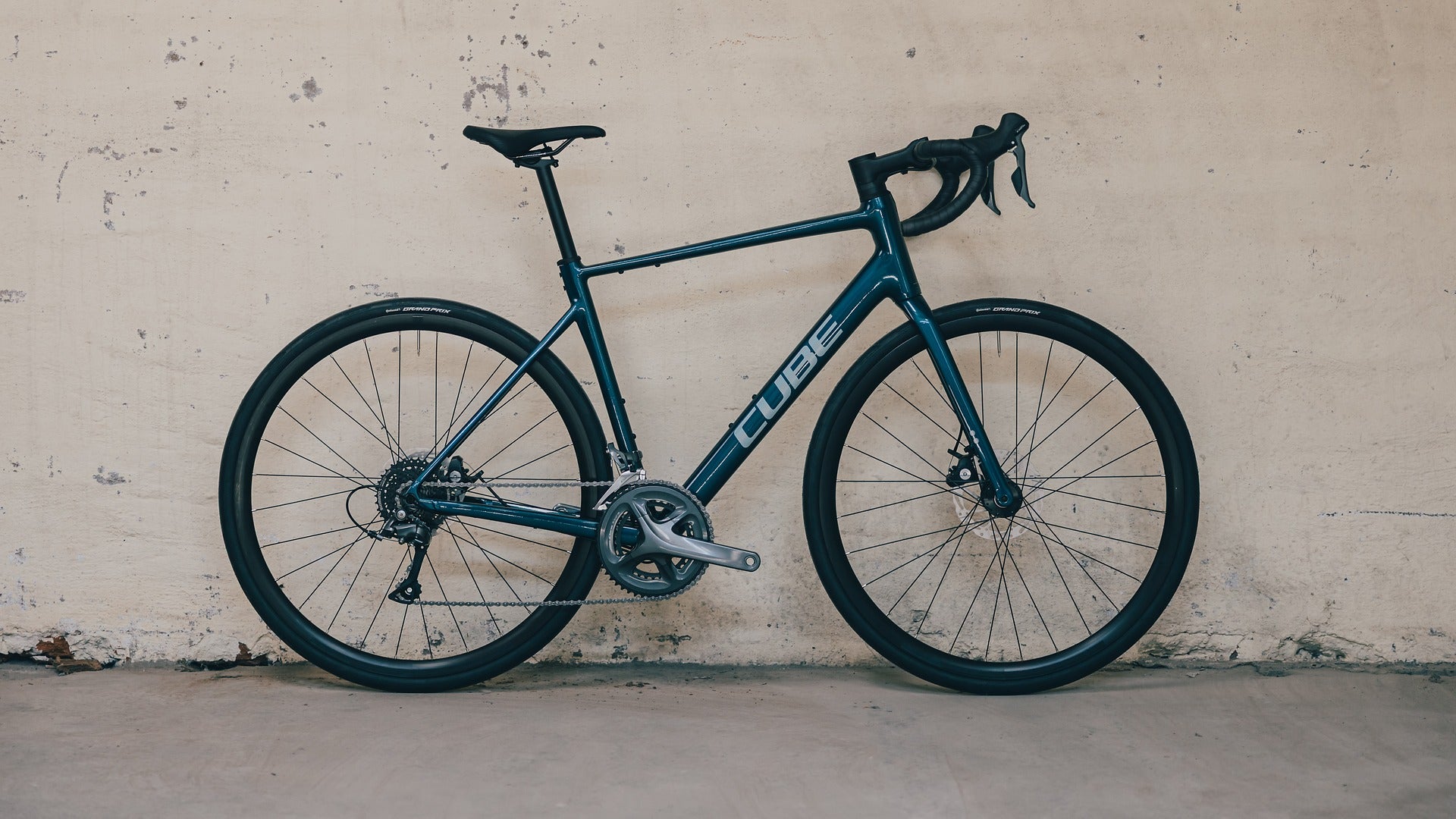 Blue Cube Road Bike leaning against a beige wall