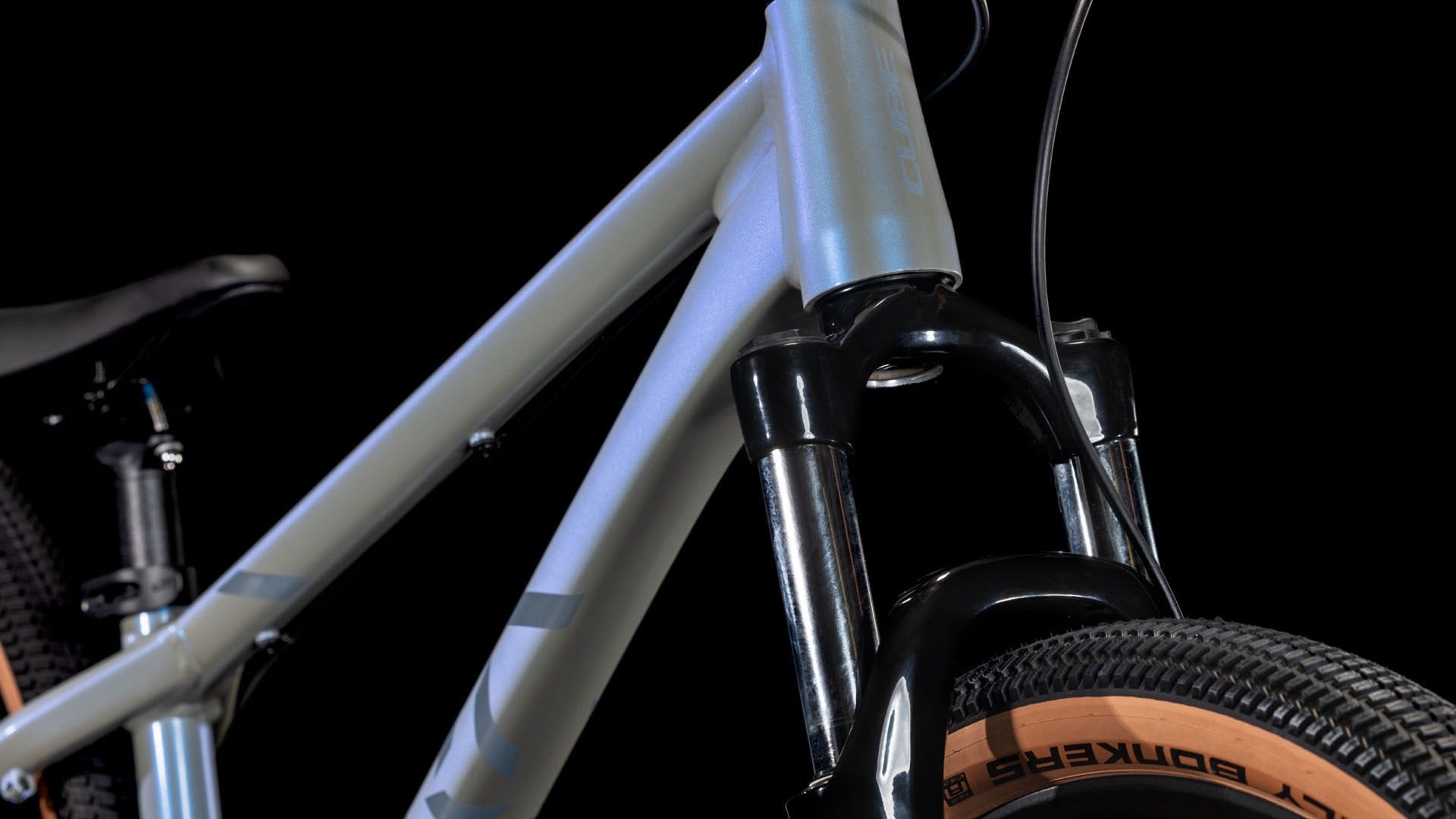 Close-up of the front suspension forks on a bicycle with a black background