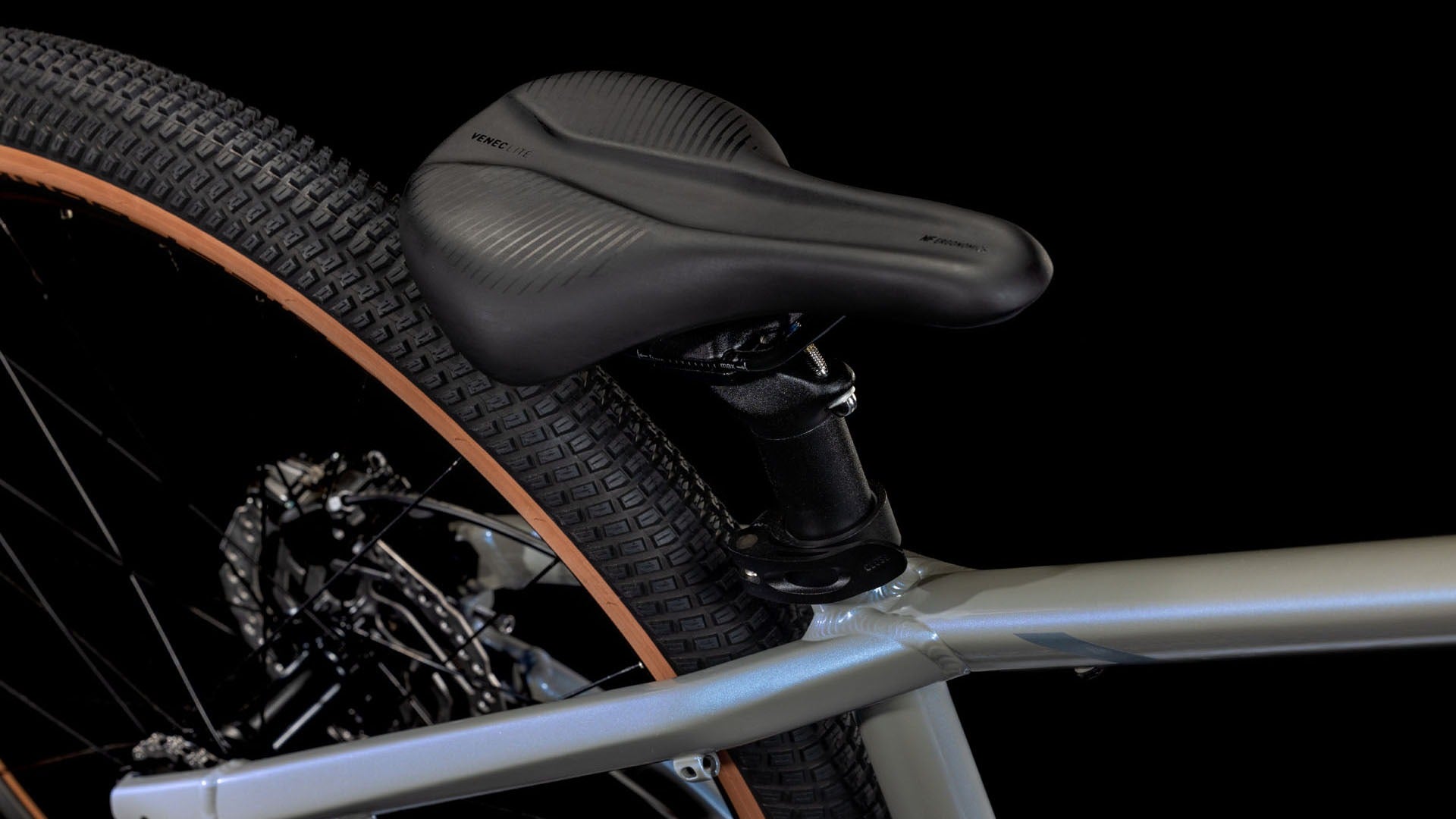 Close-up of a bicycle seat and wheel on a black background