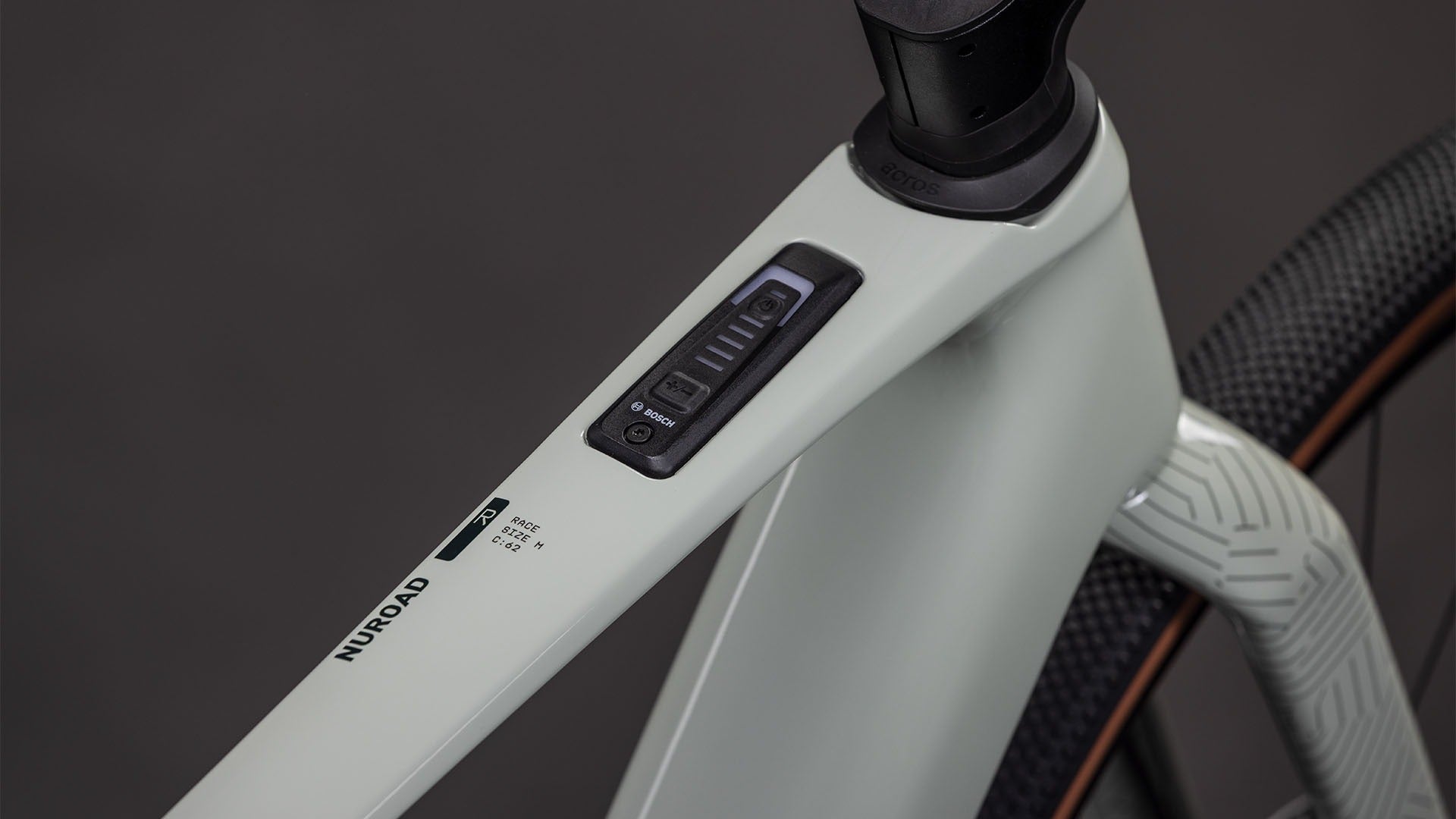 Close-up of a bicycle frame with control panel on the top tube on a dark background