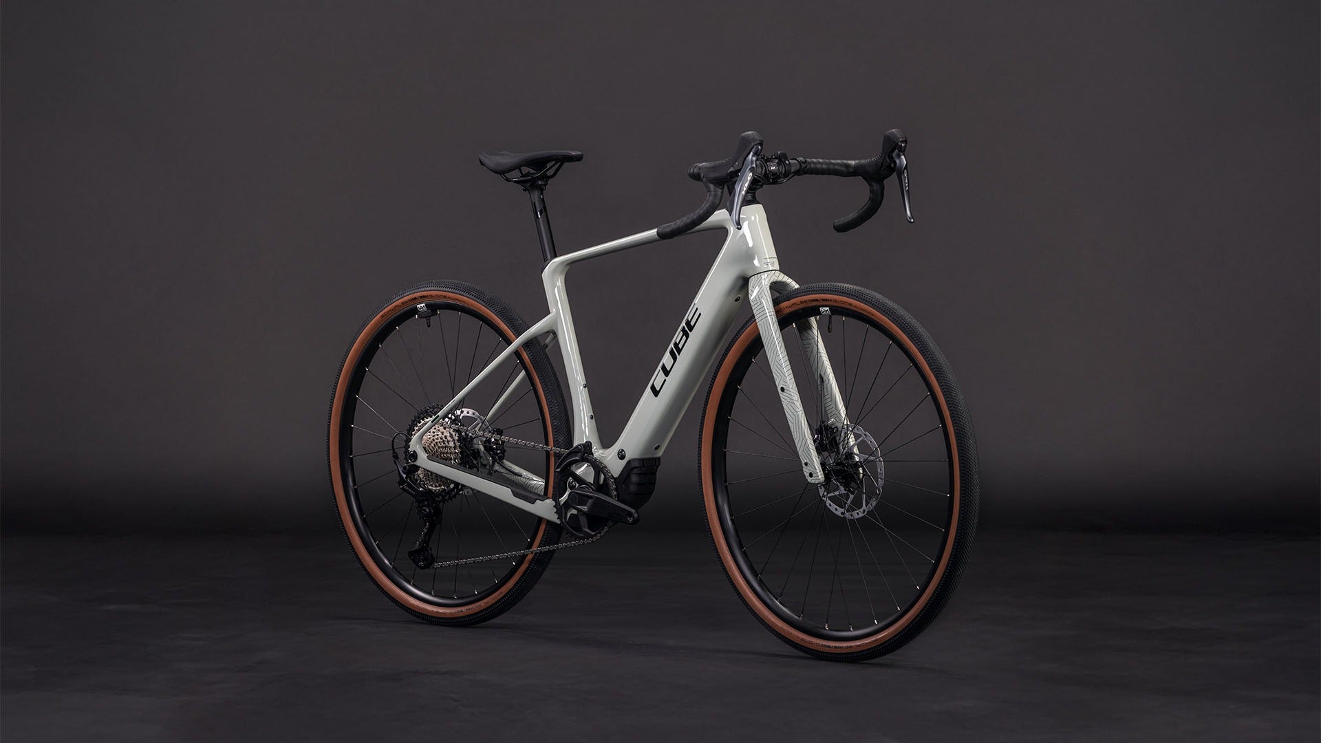 Beige Cube gravel bike with brown tyres on a dark background