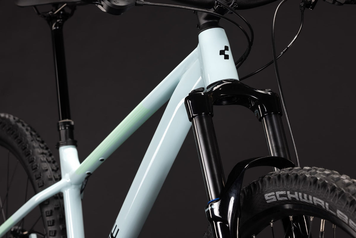 A pale blue mountain bike with a dark studio background