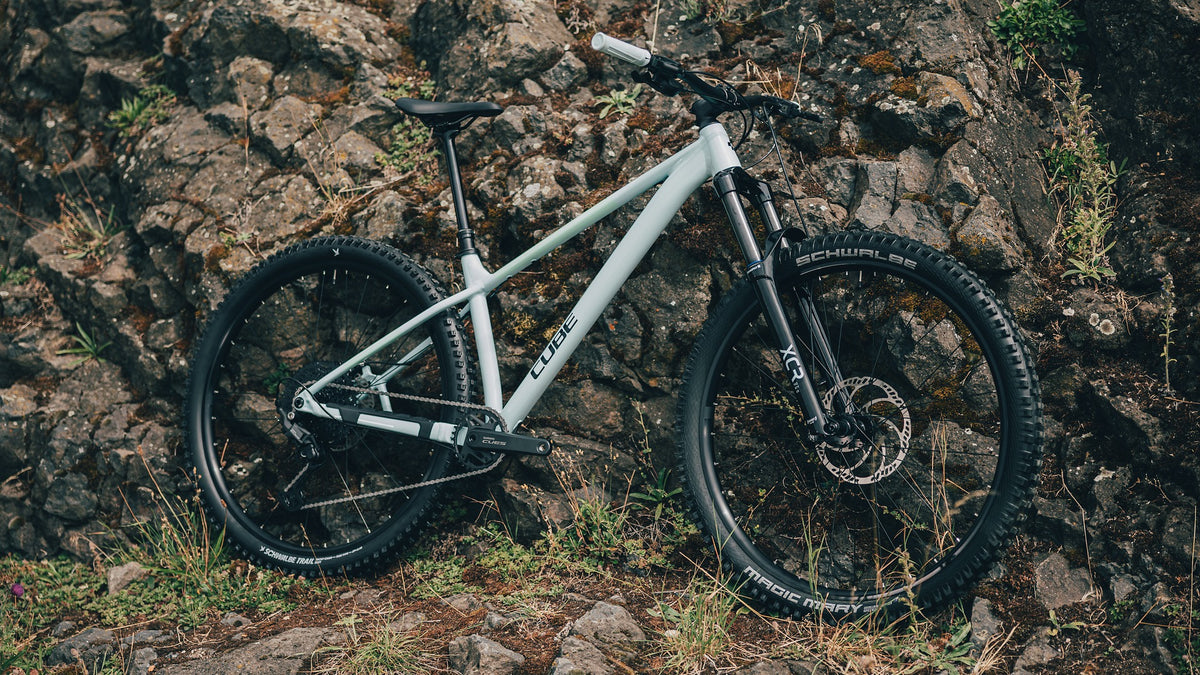 A picture of a pale blue Cube Mountain Bike against a rocky outdoor backdrop