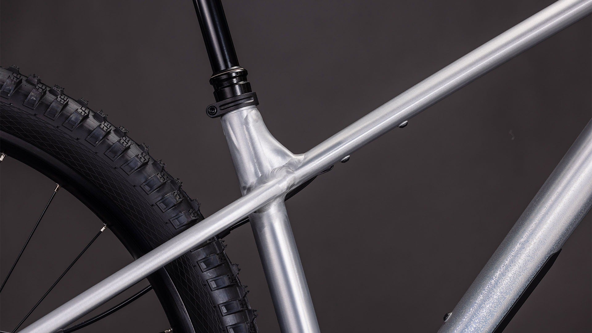 Close-up of a mountain bike frame and wheel on a dark background