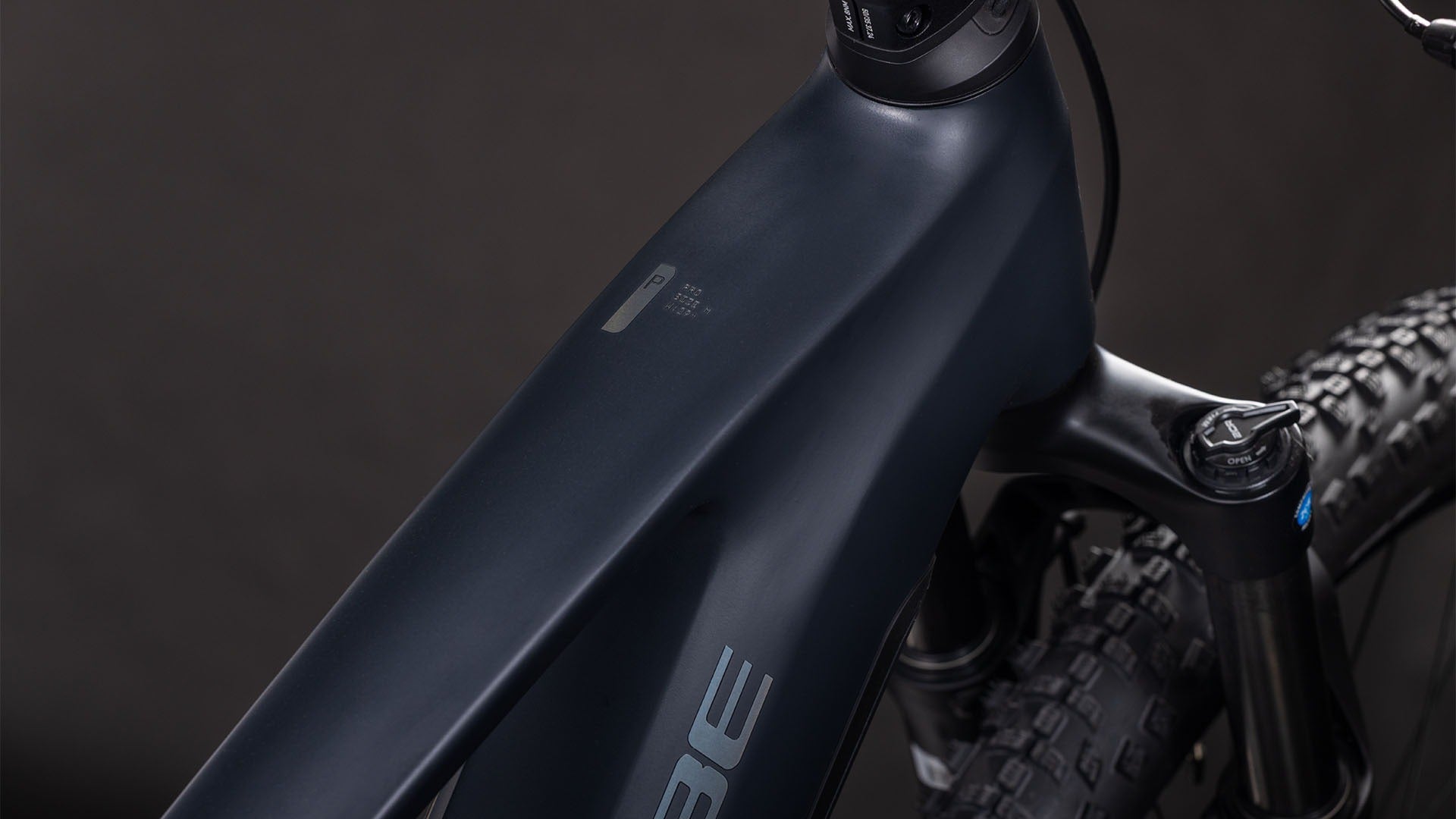 Close-up of a dark blue mountain bike frame on a black background