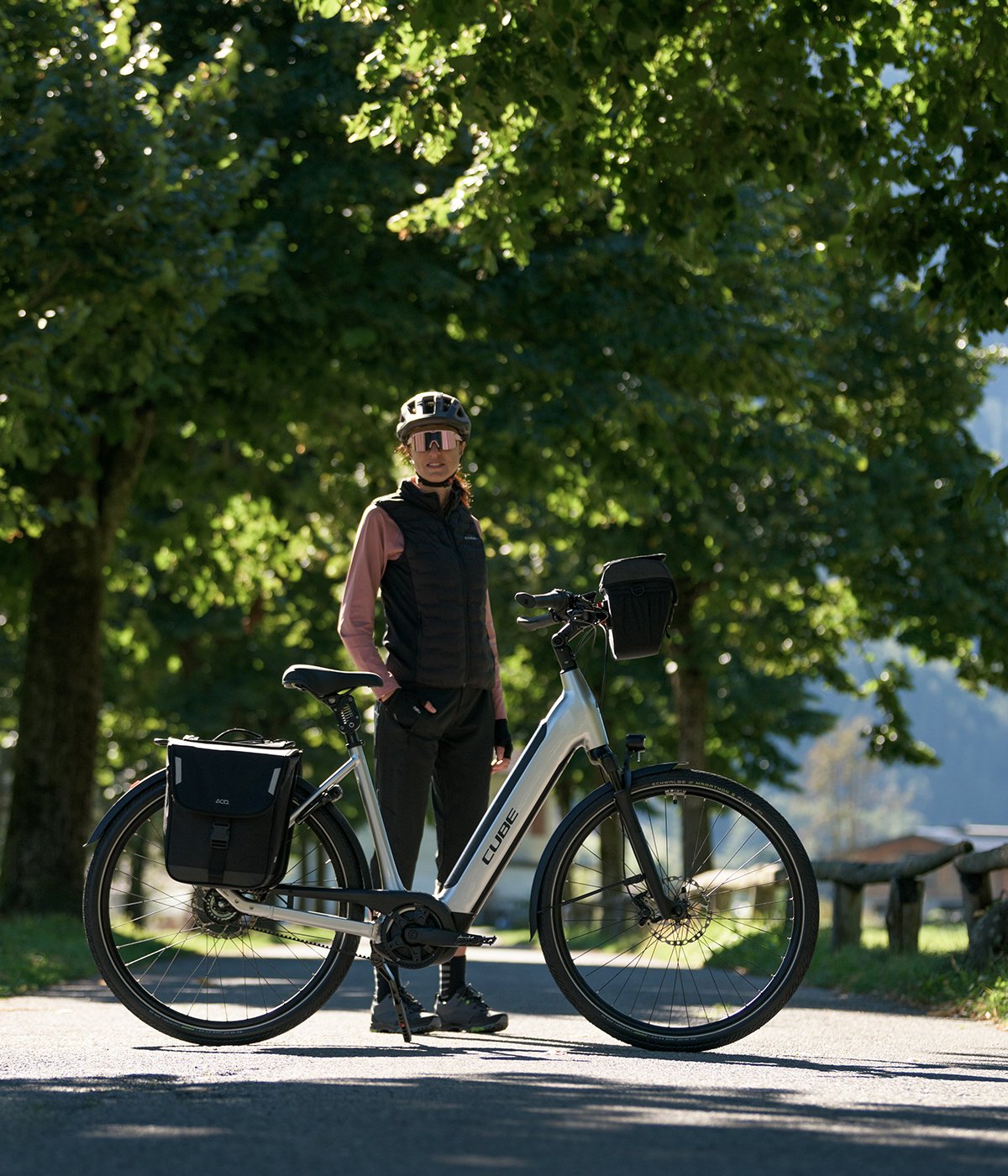 A picture of a lady standing next to a Touring Hybrid One 500 Easy Entry Electric Bike Grey Black