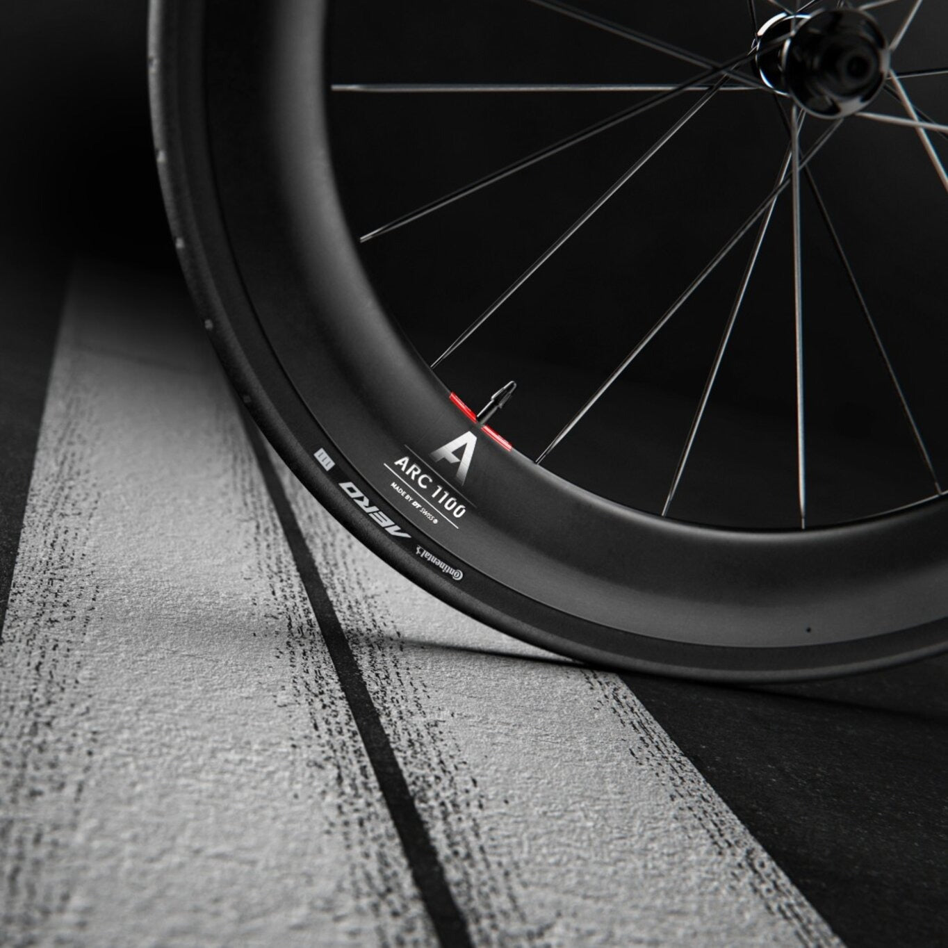 Close-up of a DT Swiss bicycle wheel with 'ARC 1100' on the rim with a dark background