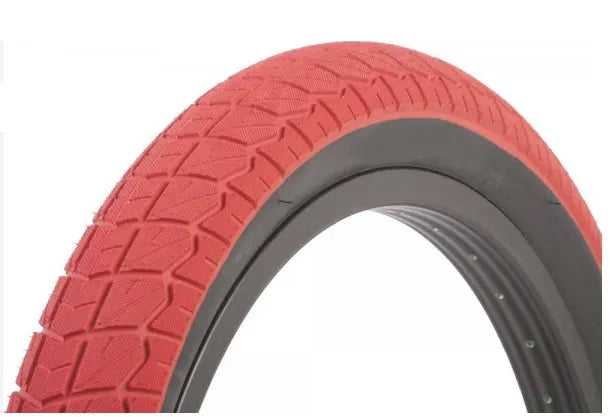 Close-up of a BMX Bike red tyre with tread pattern on a white background