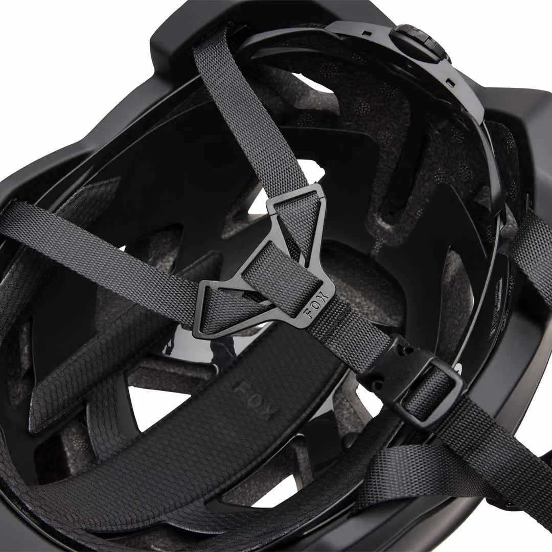 Close-up of a black FOX mountain bike helmet with straps on a white background