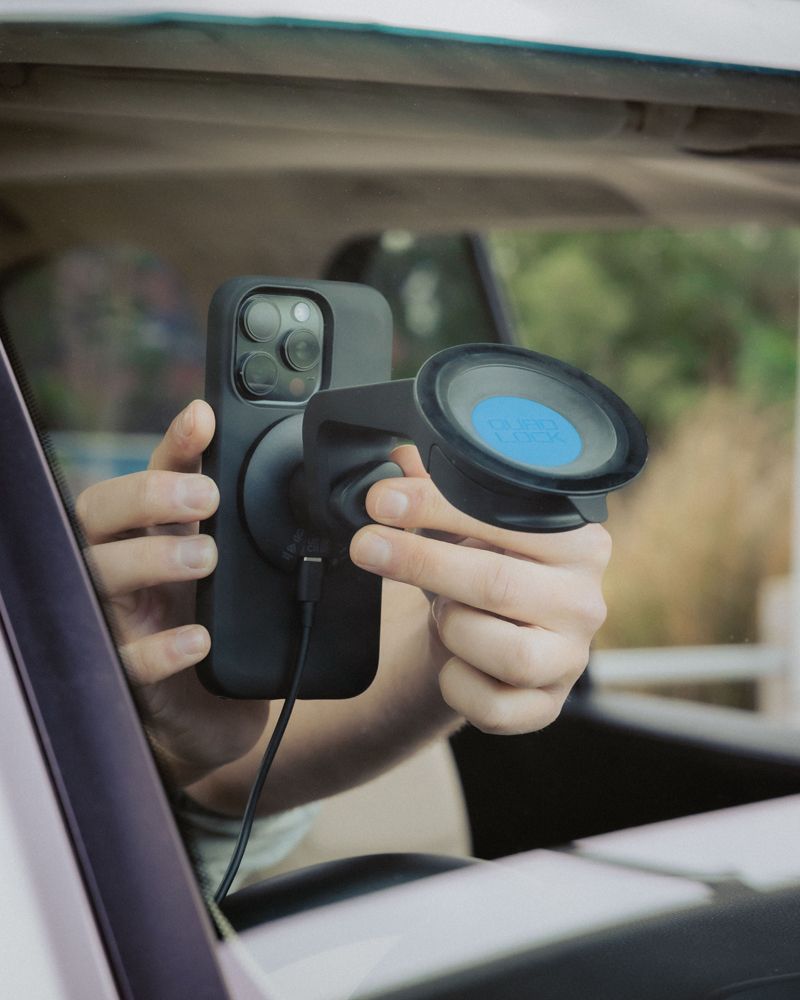 Person attaching a smartphone to a car mount inside a vehicle