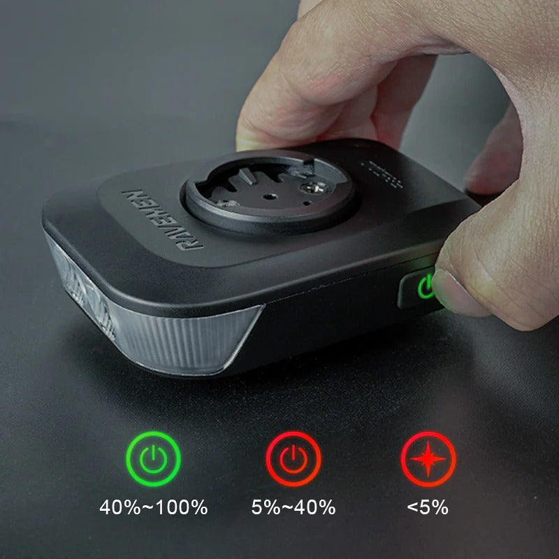 Hand holdingthe Ravemen FR500 Front Bicycle Light with charging indicators on a dark background