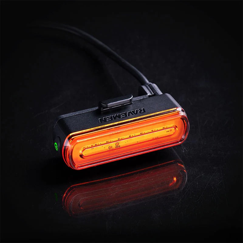 Red Ravemen rear LED bicycle light on a black background