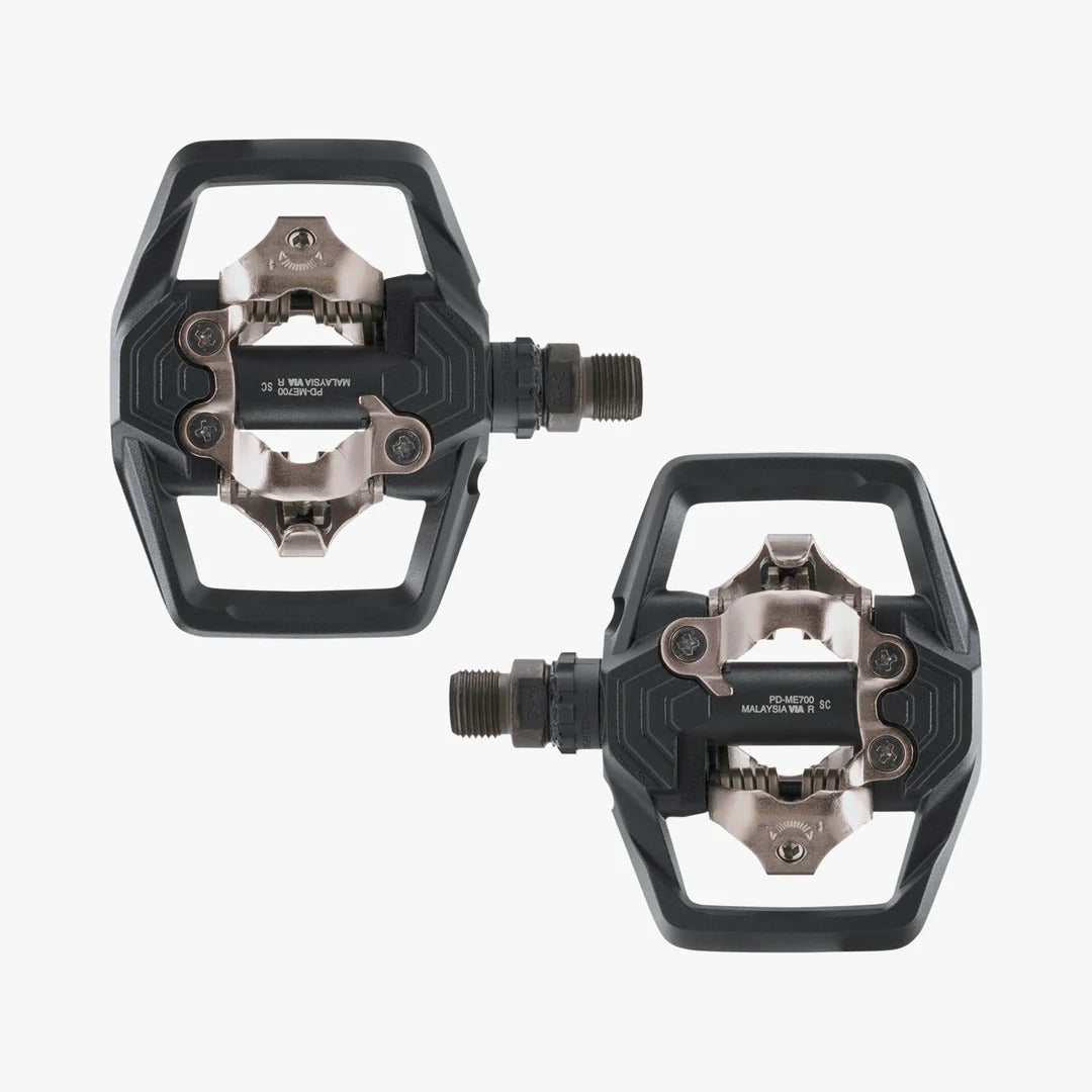 Two black and silver Shimano PD-ME700 cycling pedals shown on a light gray background.