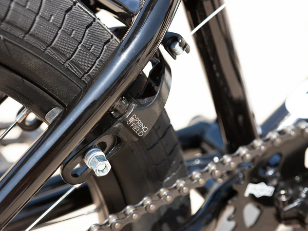 Close-up of a BMX Tyree and chain with 'Kenda' branding.