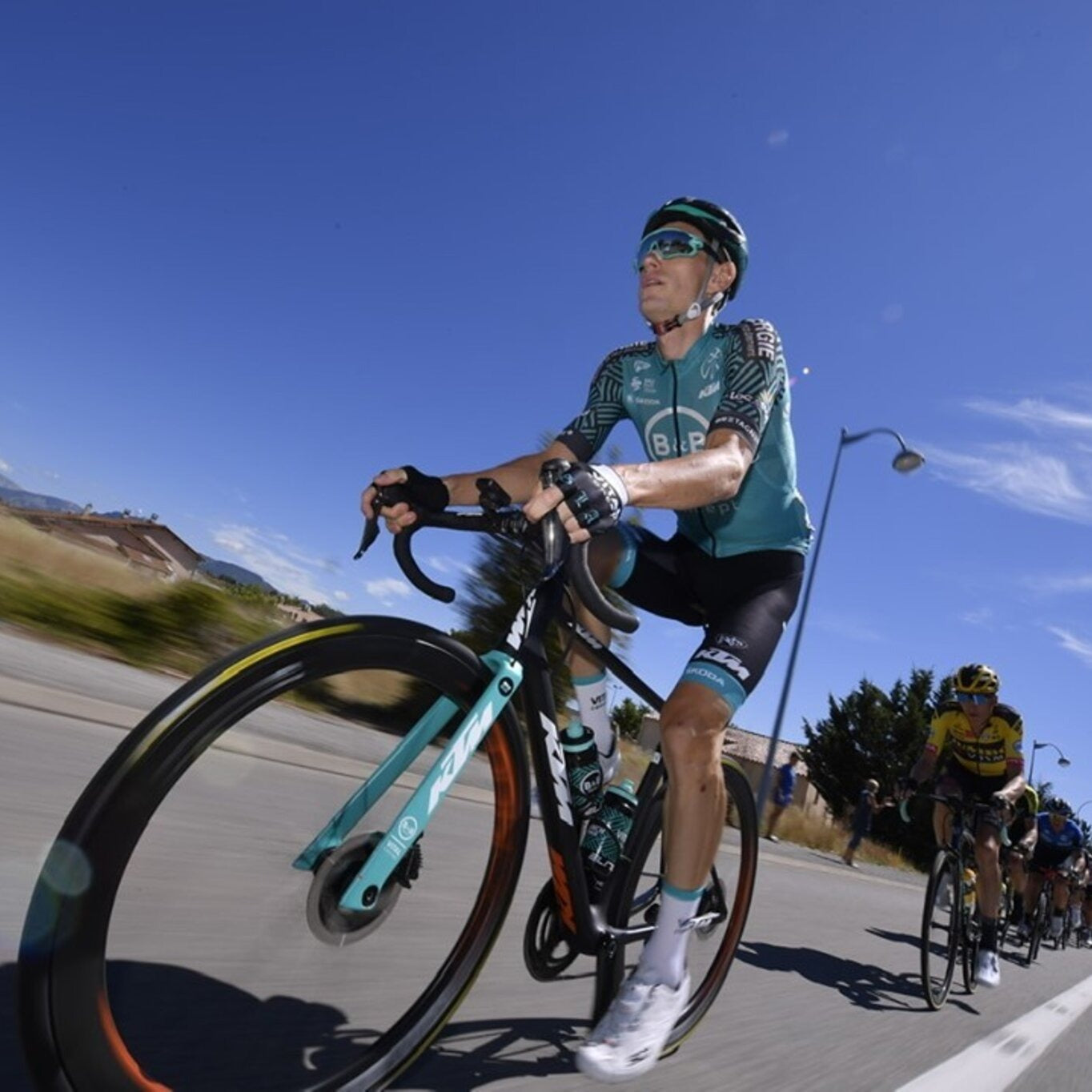 A picture of a team cyclist riding a road bike with a DT Swiss wheelset on the bike