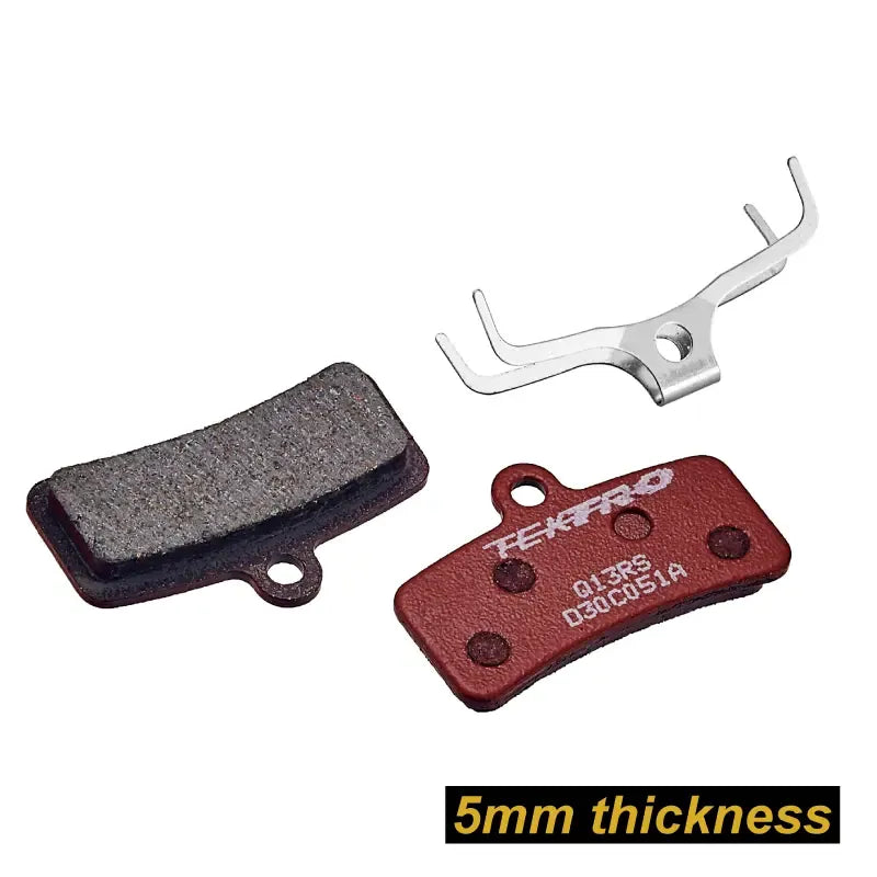 A set of Tektro bicycle disc brake pads and a silver metal spacer tool on a white background, with a black text label at the bottom reading '5mm thickness'.