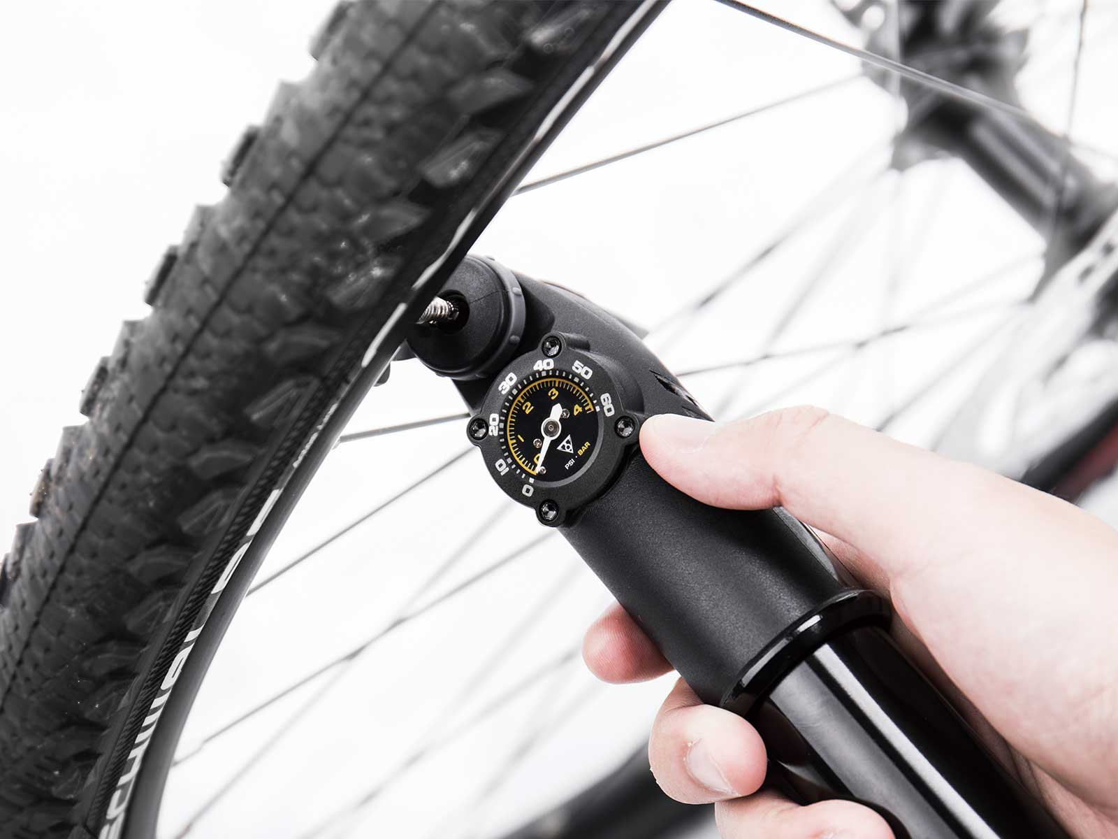 A picture of the Topeak Mountain Twin Turbo hand pump being used to pump a tyre