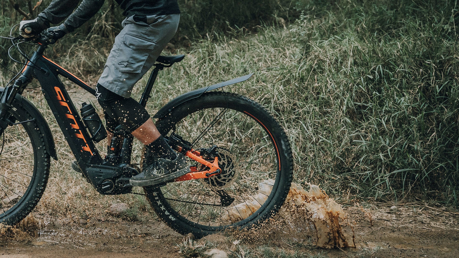 A picture of someone riding through mud with a Topeak Tetrafender M2 26-29" MTB Stay Mount Mudguard attached to bike