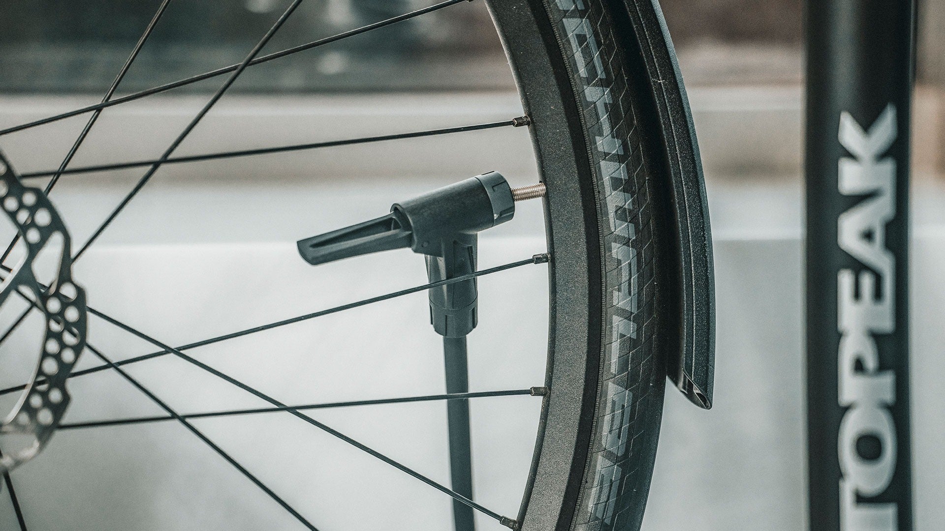 Bicycle tyre being pumped with a Topeak floor pump.