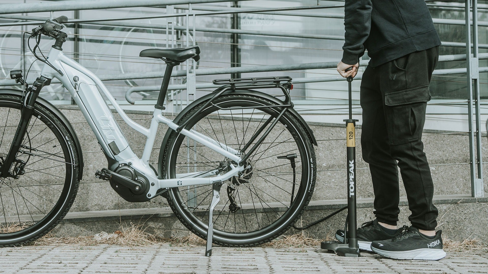 A person pumping the tyres on their bike using a Topeak bicycle pump