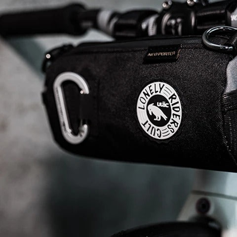Black handlebar bag attached to hybrid bike