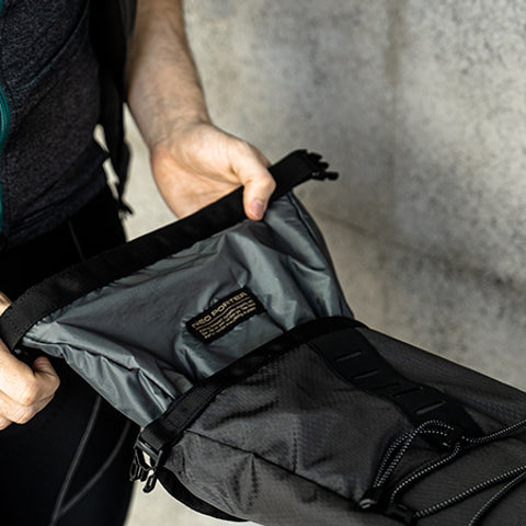 A picture of someone pulling out the waterproof bag from inside the Ulac Radtail GT Pro Saddle Bag 8.8 Litres