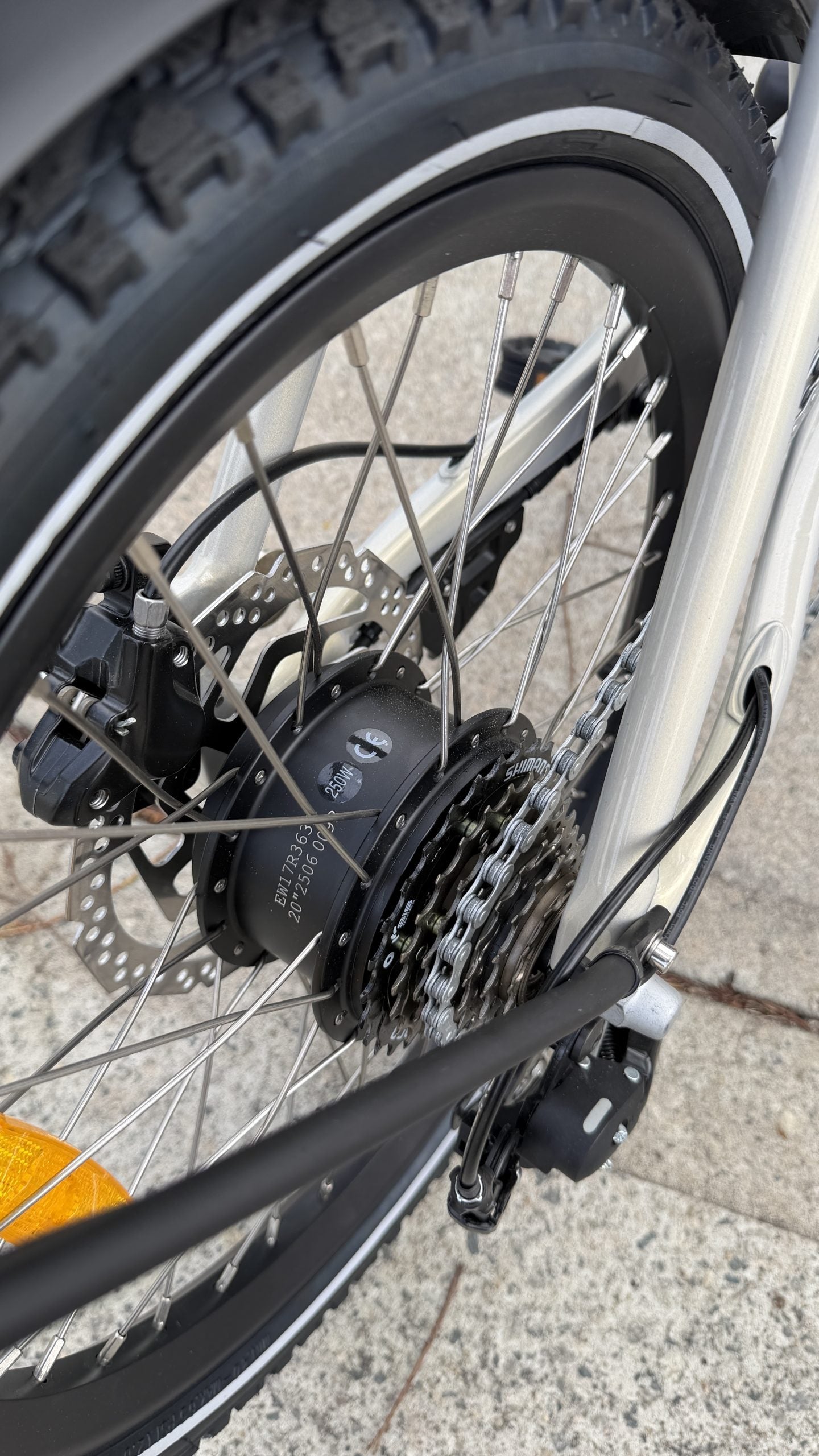 Close-up of the rear hub drive on an electric bicycle on a pavement background