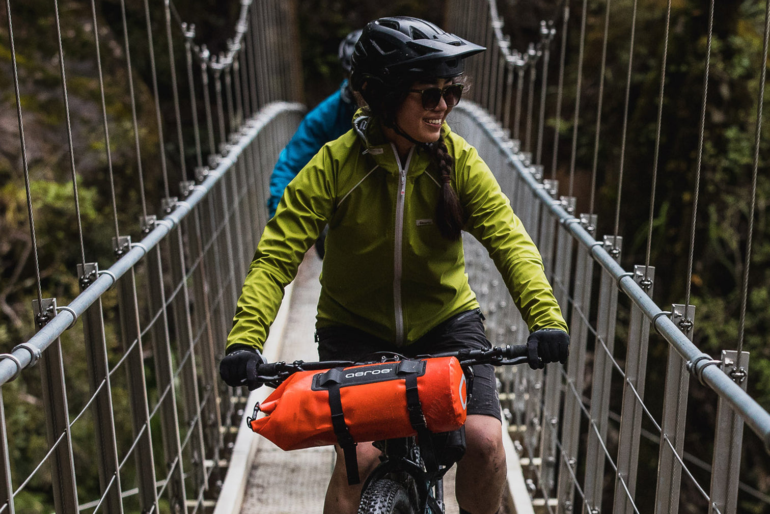 Someone riding a bike with the Aeroe 8 Litre Dry Bicycle Bag strapped to the front of the bike