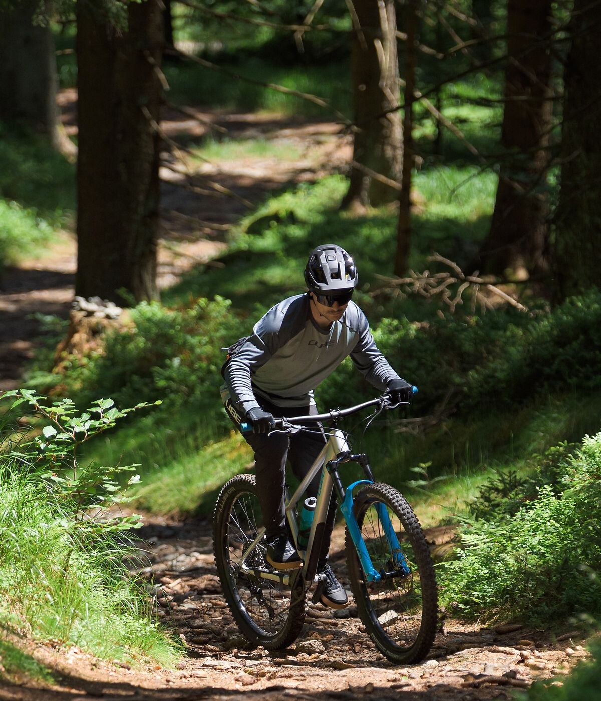 Person riding a mountain bike on a trail in a forest