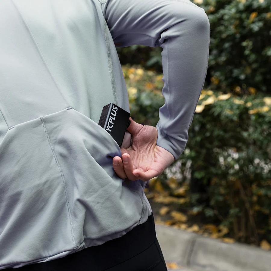 Person wearing a light gray cycling jacket putting a Cycplus electric pump in back pocket