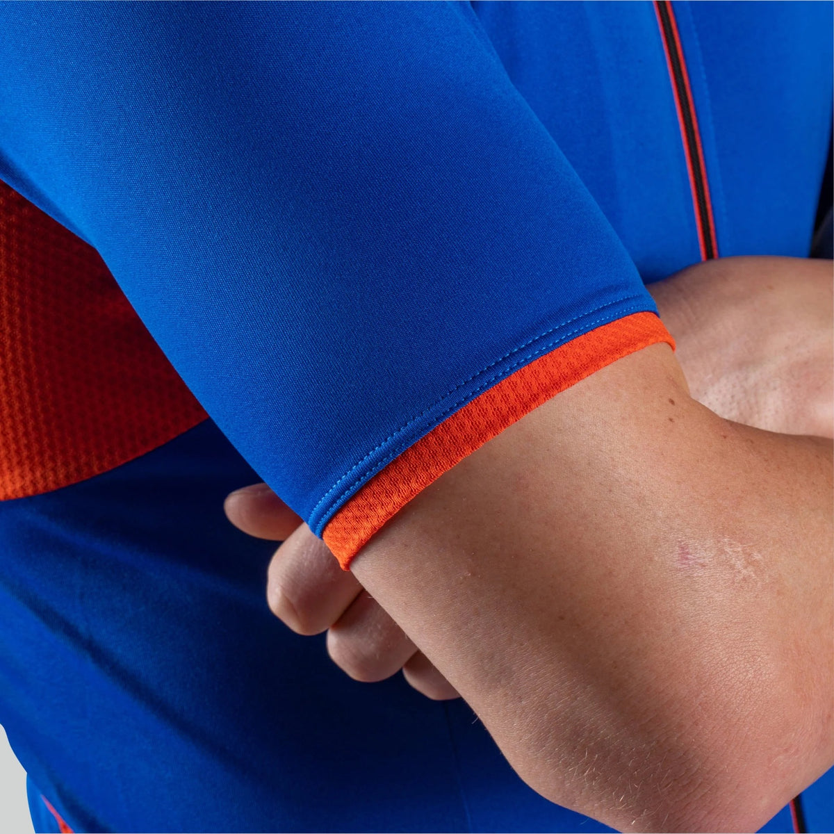 A close up of a person's arm wearing a blue cycling jersey